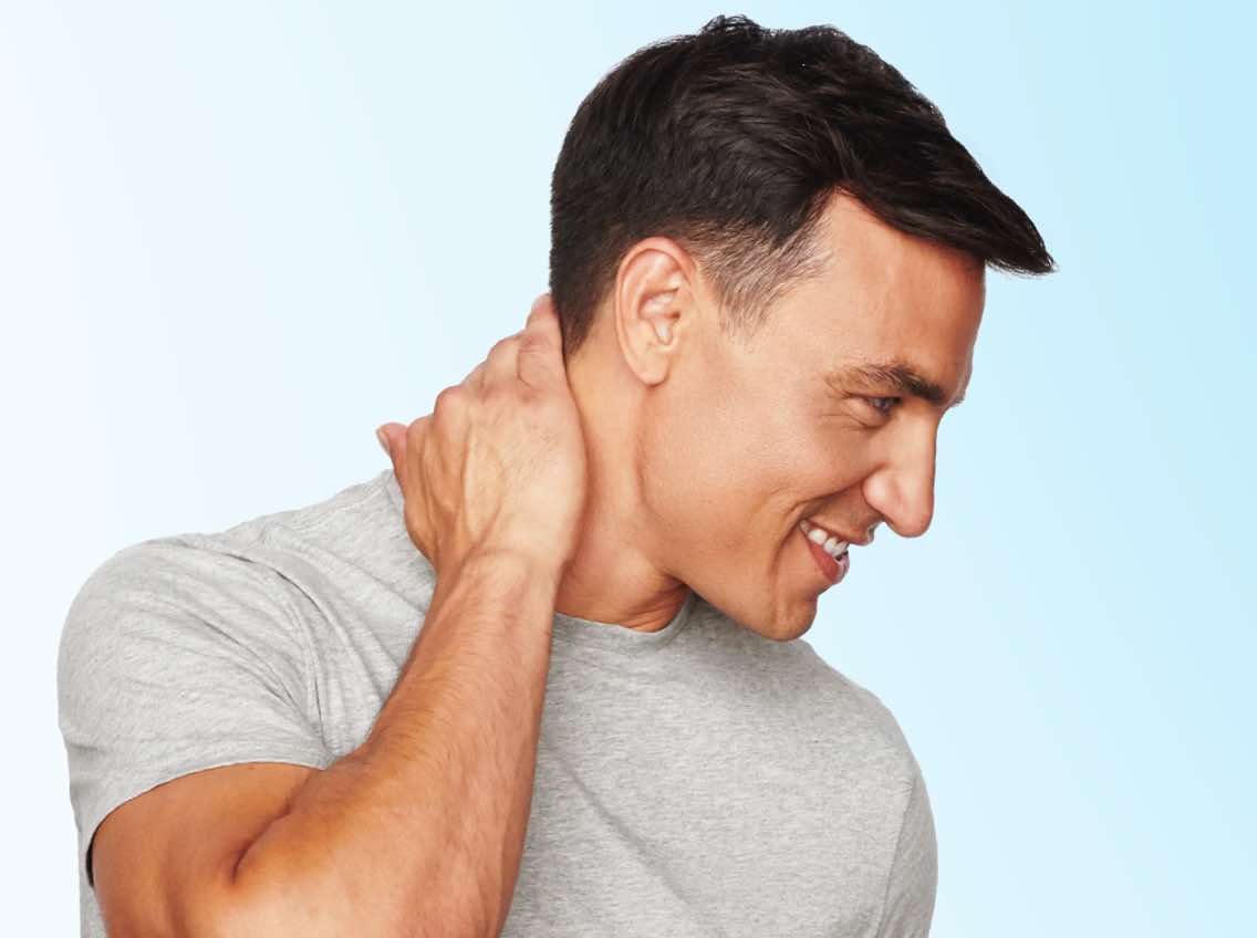 Man with short, dark hair rubbing his hand on his neck